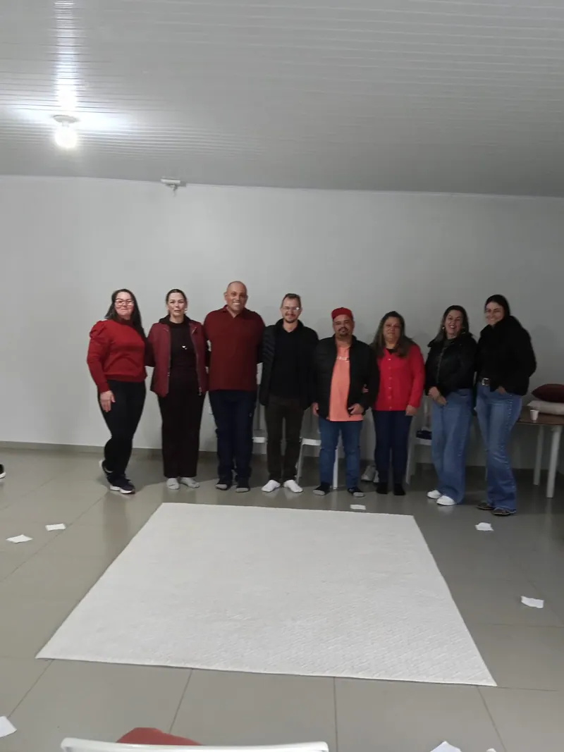 Edilson e participantes lado a lado diante do tapete branco